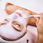 cosmetologist-applying-mask-face-client-beauty-salon_1303-16788